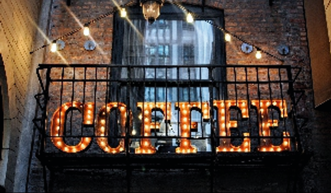 Illuminated internal signage spelling 'COFFEE' with warm lighting.