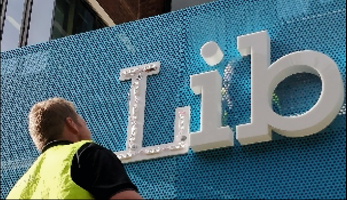 3D built-up letters mounted on a textured blue wall.